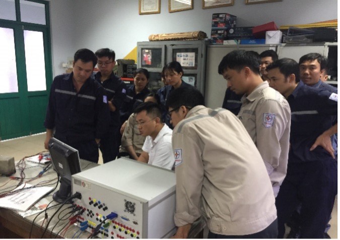 Trainees testing a digital protection relay with a relay test set